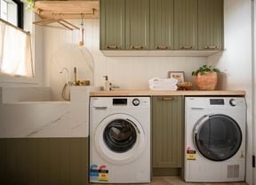 A modern laundry room featuring a front-loading washing machine and a matching dryer placed side-by-side.