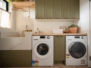 A modern laundry room featuring a front-loading washing machine and a matching dryer placed side-by-side.