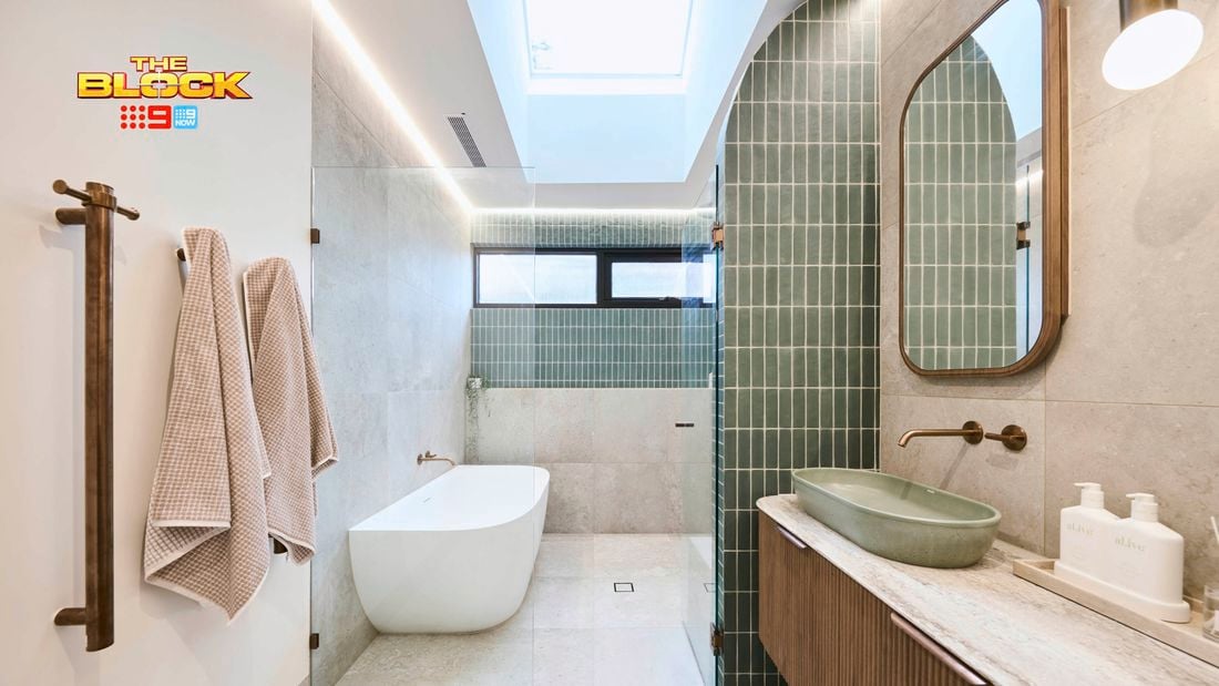 Green and white coloured bathroom with a timber fluted profile vanity and marble benchtop and bath