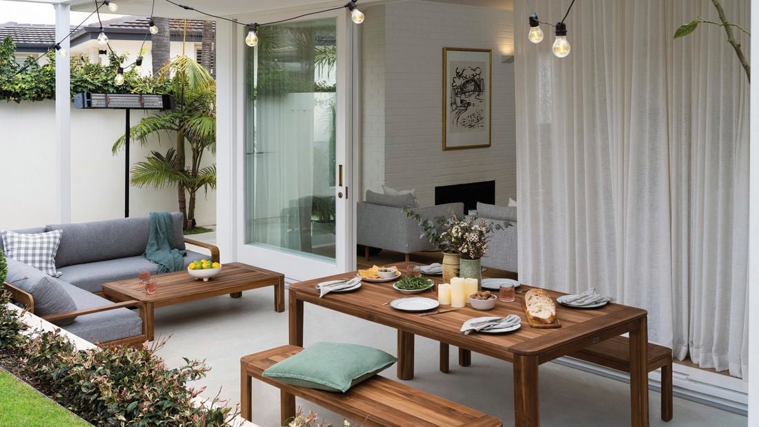 Outdoor area set for a party with lights, furniture and food.