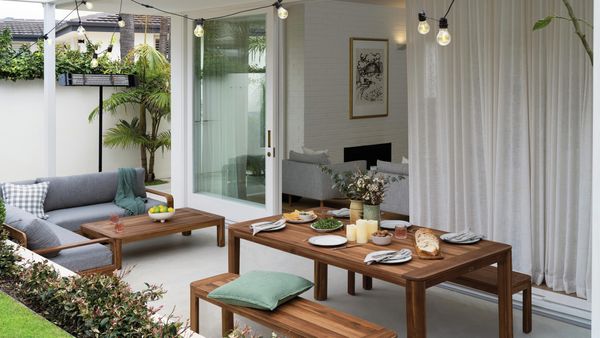 Outdoor area set for a party with lights, furniture and food.