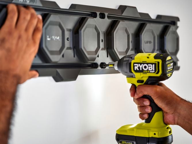 Impact driver fixing screw into LINK wall rail.