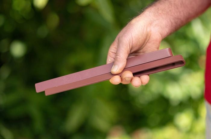 Hand holding garden edging pegs.
