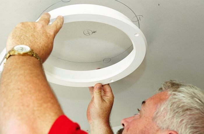 A skylight diffuser template being used to mark a hole in the ceiling to be cut to make way for Mylar tubing to come in from above