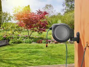 Gardena hose reel attached to wall in garden