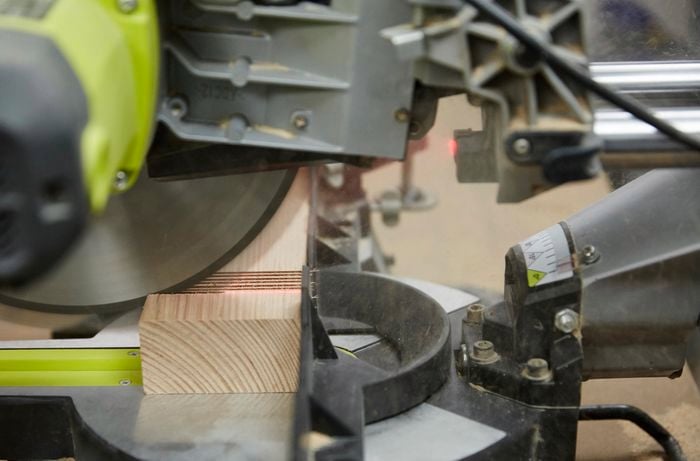 Person cutting rebate out of timber table leg