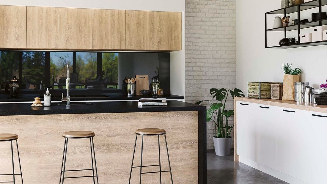 Kitchen with concrete floors, timber cabinets and black benchtop.