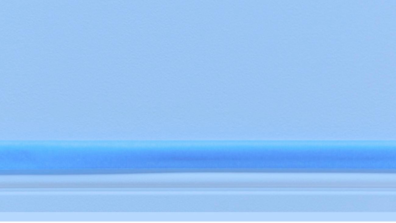 A light blue wall with blue Scotch tape attached to the top edge of a skirting board