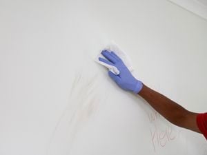 Cleaning a wall using a wipe. 