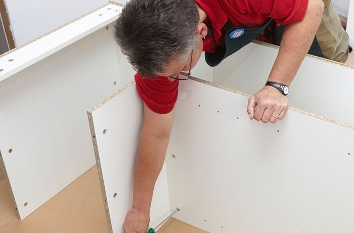 Person screwing into a panel.