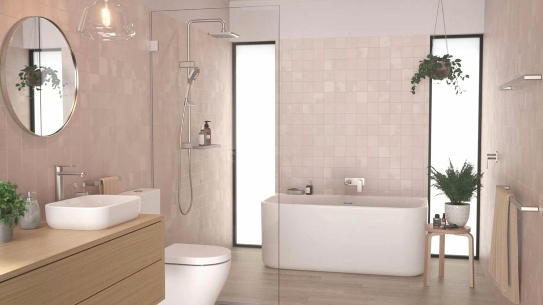 A modern Caroma bathroom in neutral tones featuring a freestanding bathtub flanked by floor-to-ceiling windows, a frameless shower screen and a timber vanity