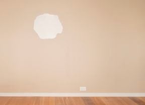 An image of a large hole in the plasterboard wall