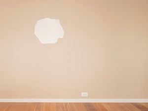An image of a large hole in the plasterboard wall