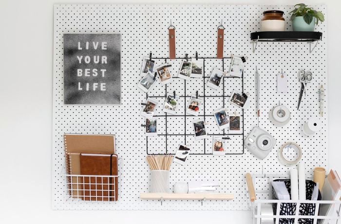 Pegboard with photos, craft tools and an inspirational quote on canvas