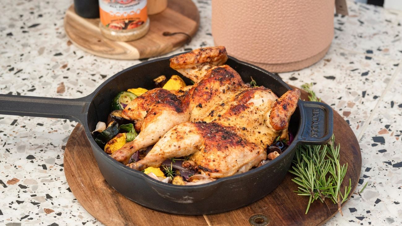 BBQ chicken pieces in a black frying pan.