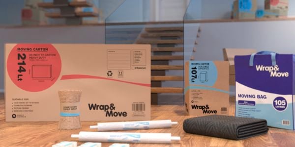 cardboard packing boxes, bubble wrap, wrapping paper, pens laid out on the floor