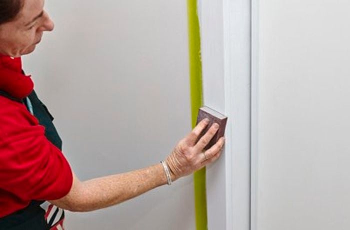 Person sanding door trims.