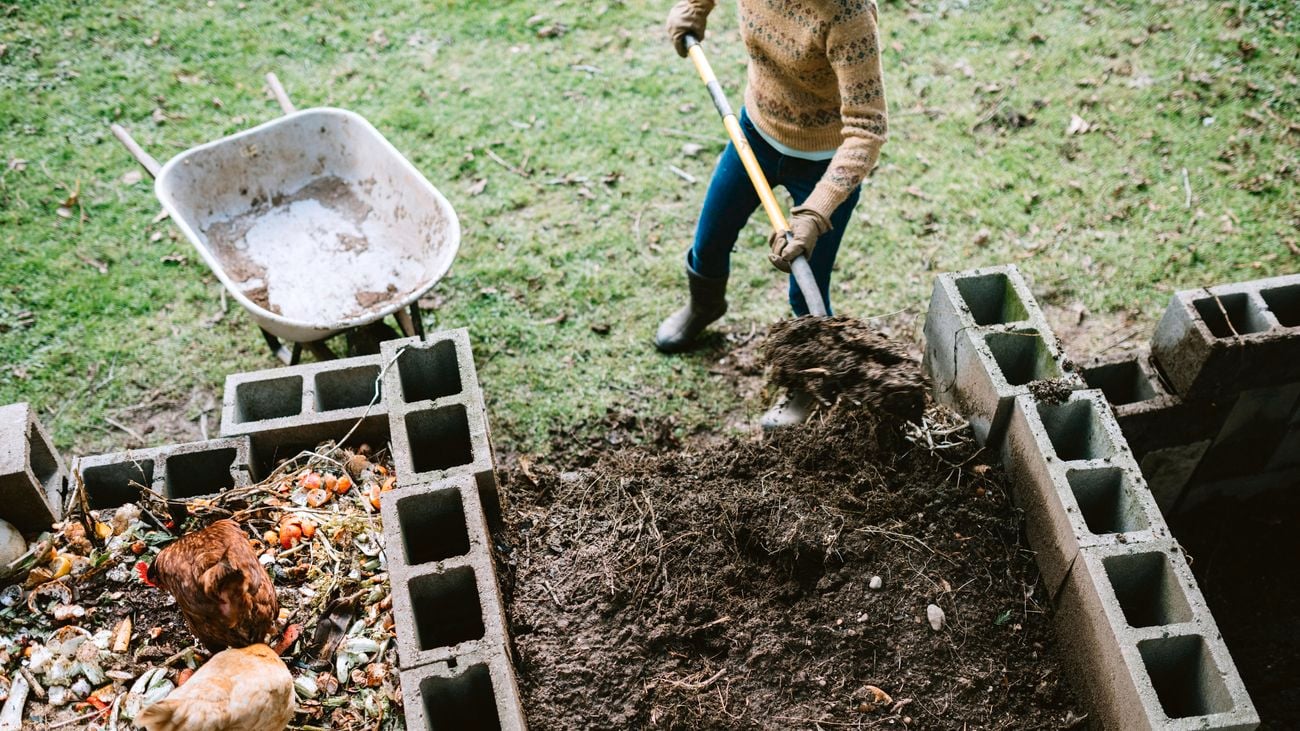 A person shovelling compost.