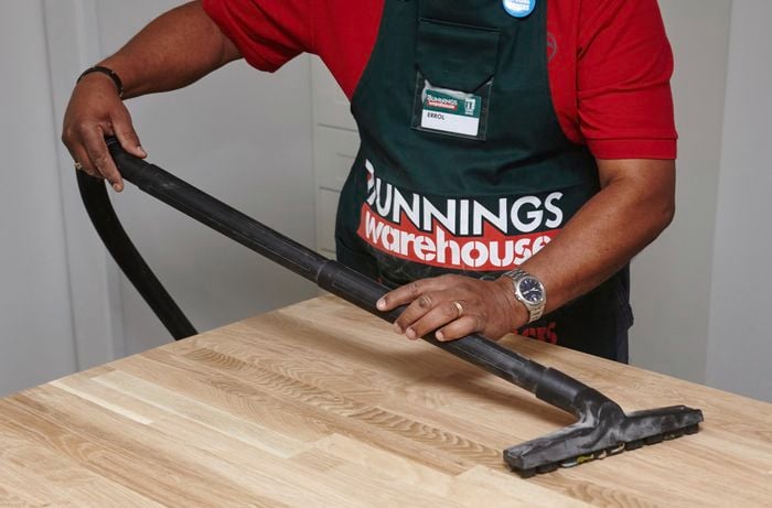 Person using vacuum on benchtop.