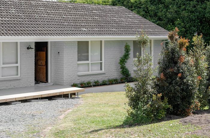 The front of a house with a gravel driveway