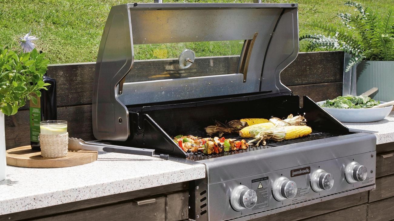 Barbecue and benchtop in outdoor space cut out of lawn slope