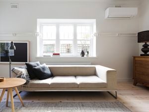 Styled living room featuring an air conditioner, beige sofa, timber coffee table and console