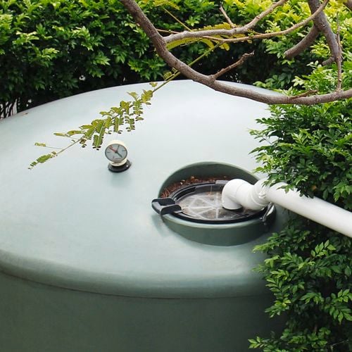 Maintenance tray on top of a green rainwater tank.