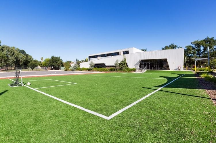 A soccer pitch in front of a modern building