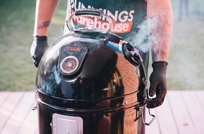 Person standing next to a bullet smoker with smoke coming out