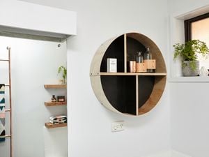 Shelving inside a circular timber frame on a bathroom wall