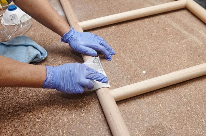 Person sanding DIY wooden towel ladder.