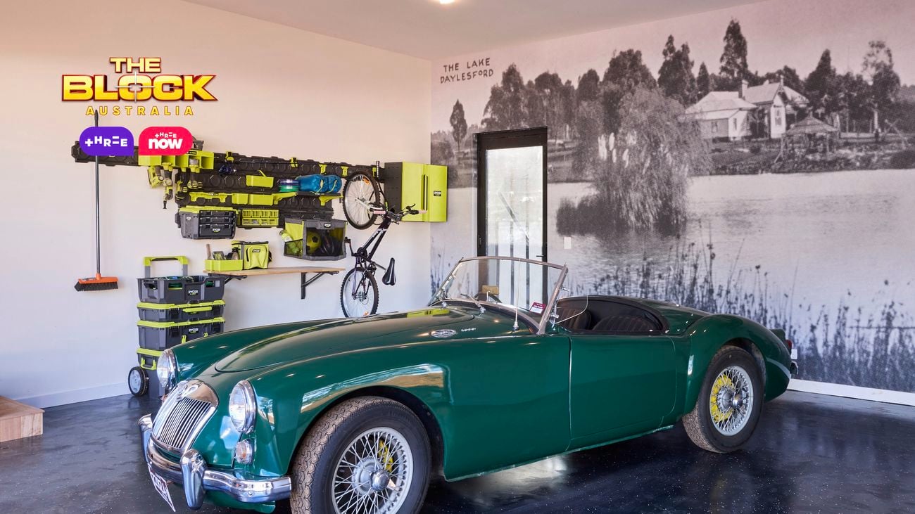 Modern garage from The Block featuring a green vintage car, wall mural, tool storage, and polished dark flooring.