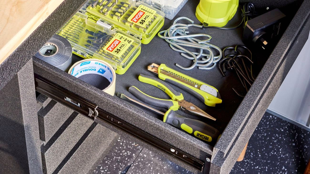 An open workbench drawer showing organised tools