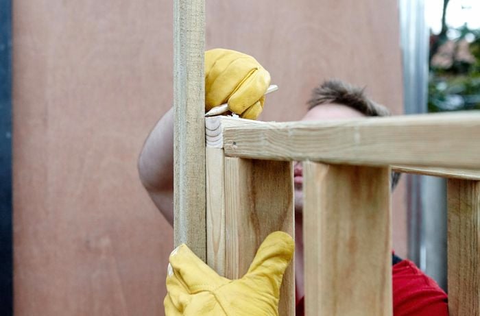 Person marking up timber frame pieces.