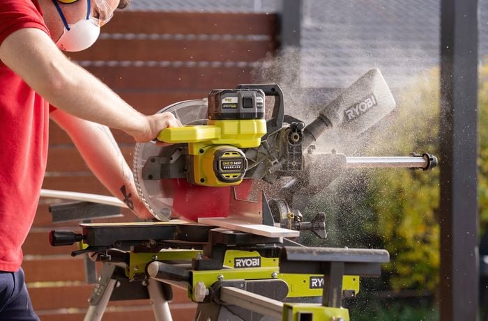 A person is using a drop saw to cut the MDF battens, which are easy to work with and come ready to paint.