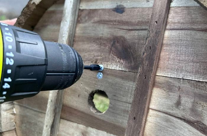 Drilling through base of a barrel planter to secure stakes with two screws