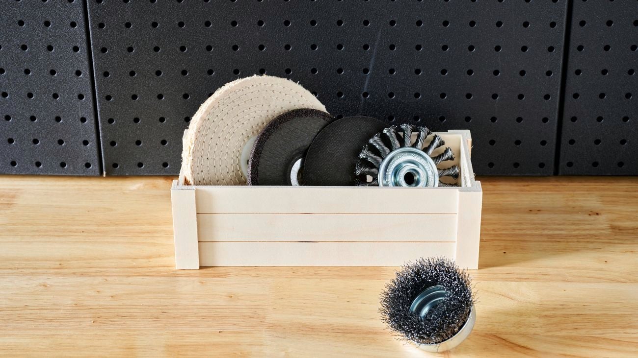 Four grinder accessories in wooden box with wire brush outside of the box.
