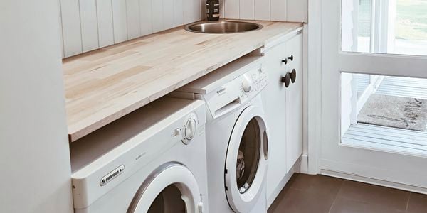 Laundry with washing machine and timber benchtop.