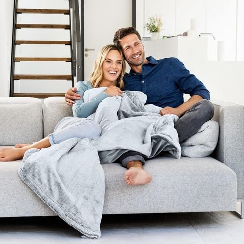 A lady and man sitting together on a couch