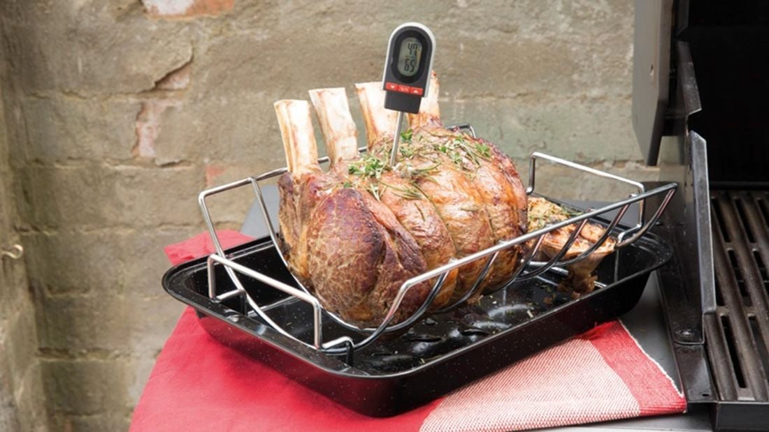 Rack of lamb ribs with thermometer stuck into it.