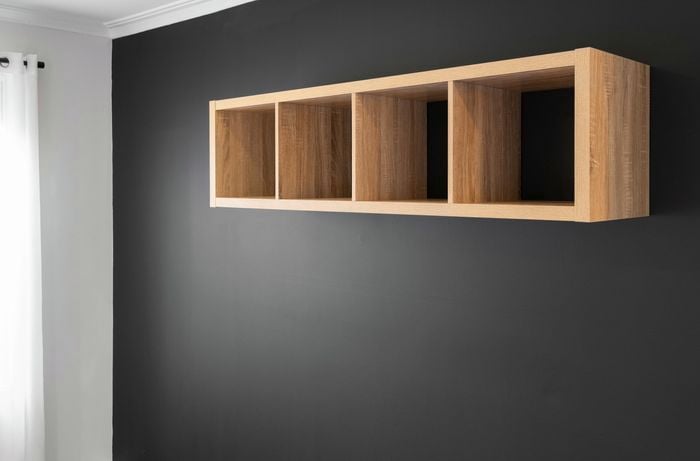 A shelf attached to a darkly painted wall