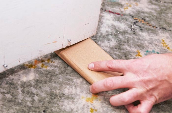 Person putting door stop under door.