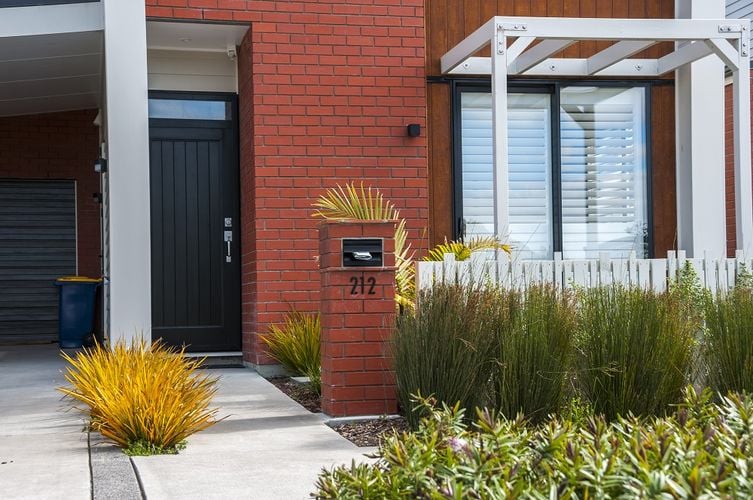 Exterior of a red brick townhouse with a black front door
