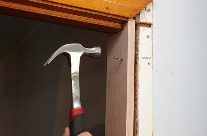 A new door jamb being nailed into place