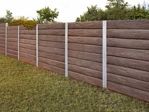 A wooden fence with horizontal planks and vertical metal supports, set in a grassy area.