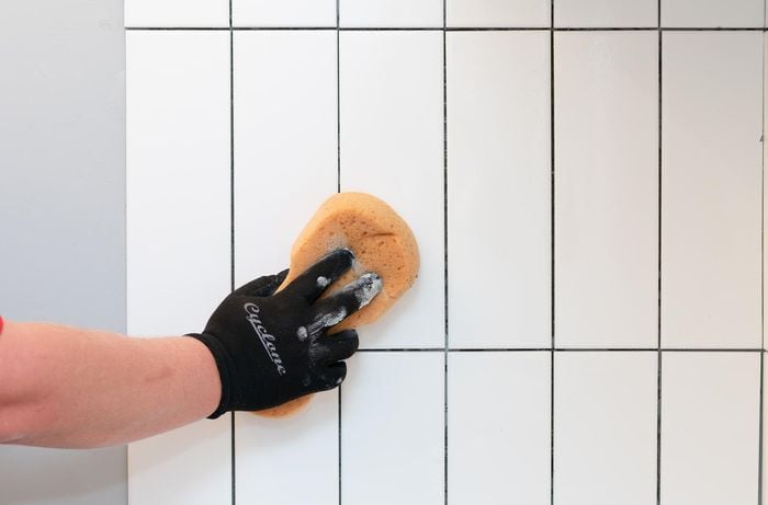 cleaning the new tiles with sponge