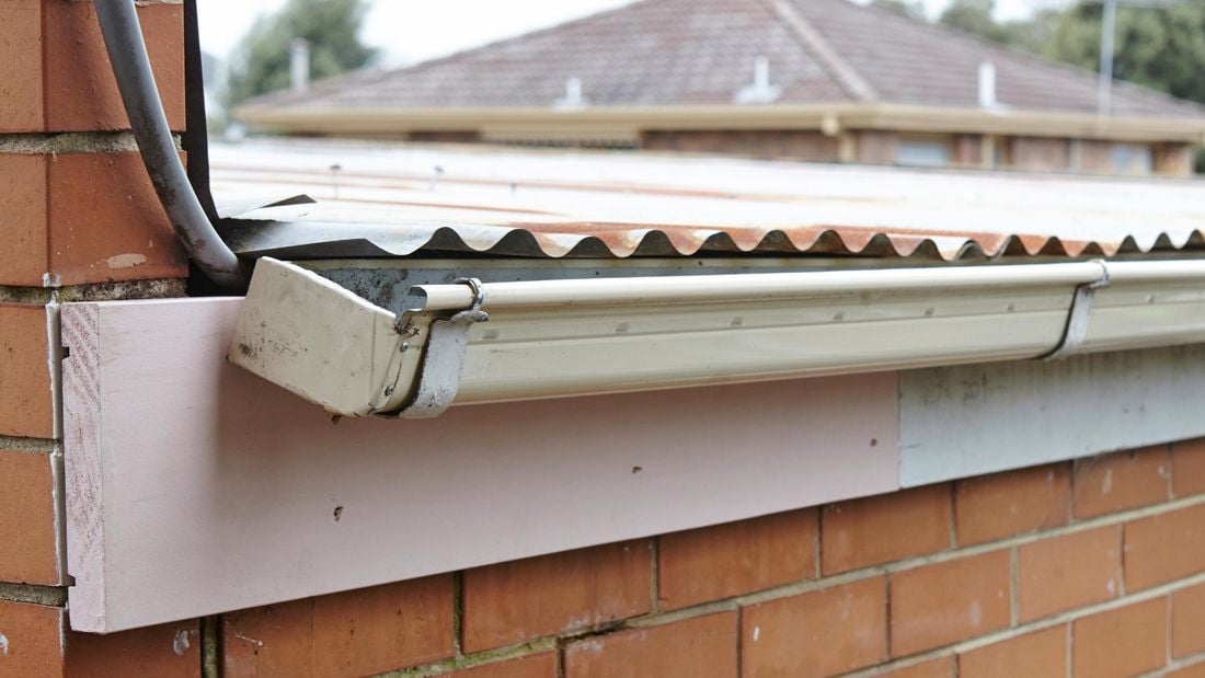 Guttering hanging from a new section of timber fascia board