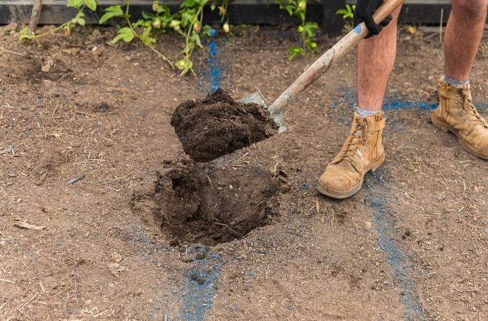 Dig post holes in the marked ground with a shovel