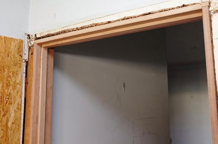 A new door jamb positioned in a doorway