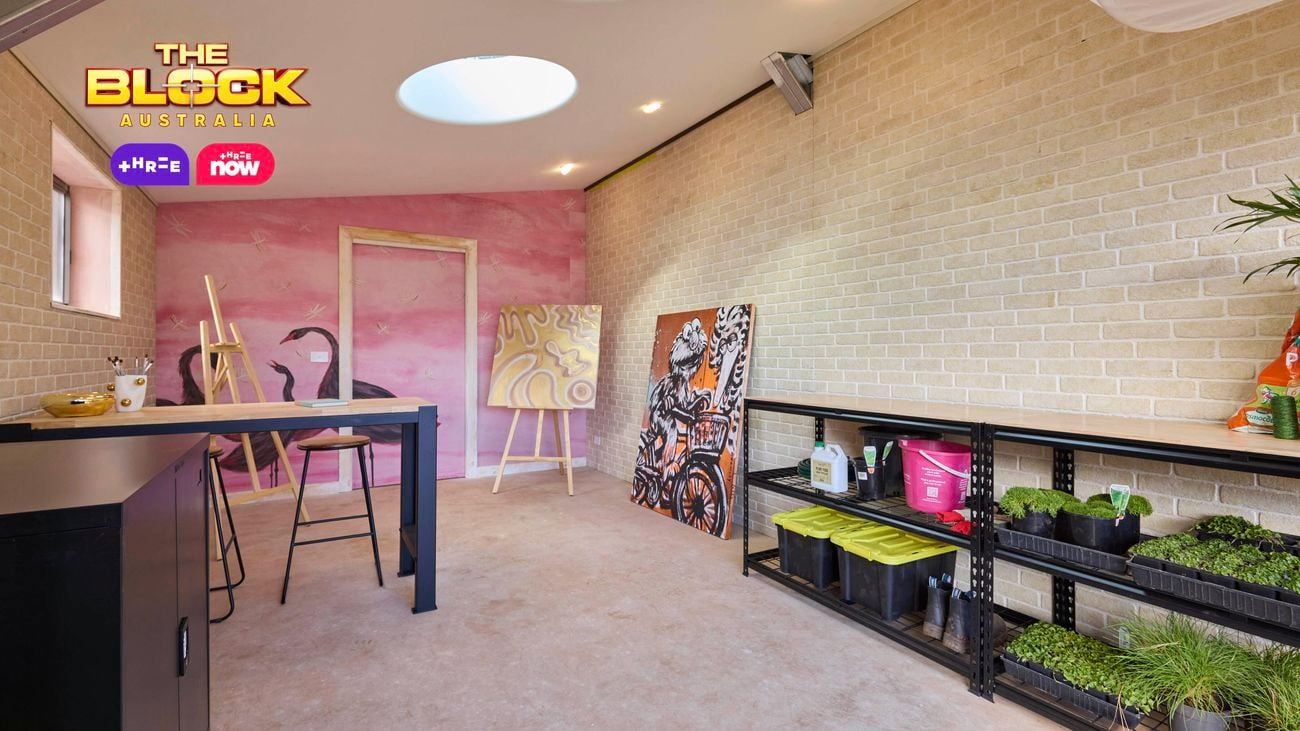 A room with paintings, storage containers and plants in it.